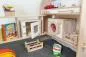 Preview: Mikrowelle, Backofen aus Naturholz in Spielständer mit Erweiterung eingebaut. Mit Waschmaschine und Tischküche natur-weiß, Obststiegen, Büchern und Spielzeug