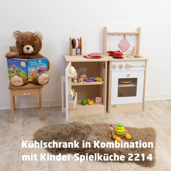 Kind spielt mit Spielküche, räumt das Geschirr ein